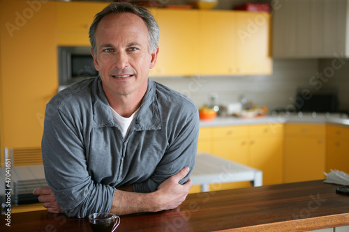 Photo: Man leaning on kitchen surface Man leaning on kitchen surface