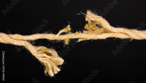 Photo: Breaking rope isolated on black Breaking rope isolated on black