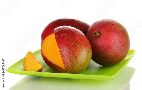Photo: Ripe appetizing mango on green plate isolated on white Ripe appetizing mango on green plate isolated on white