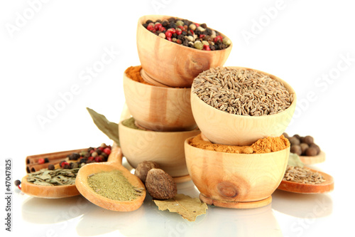 Photo: wooden bowls and spoons with spices isolated on white wooden bowls and spoons with spices isolated on white
