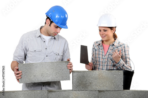 Photo: Bricklayer and apprentice with a block wall Bricklayer and apprentice with a block wall