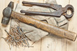 Vintage hammer with nails on wood background