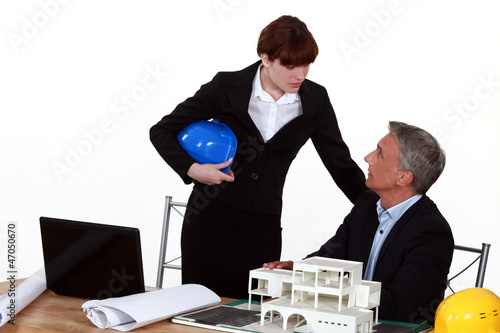 Photo: real estate businessman and businesswoman in their office real estate businessman and businesswoman in their office