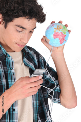 Photo: Man holding mobile telephone and miniature globe Man holding mobile telephone and miniature globe