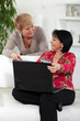 Photo: Two middle aged friends shopping online. Two middle aged friends shopping online.