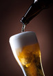 beer glass and bottle on a brown