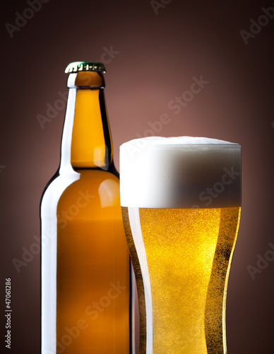 Photo: beer glass and bottle on a brown beer glass and bottle on a brown