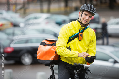 Photo: Male Cyclist With Courier Bag Using Mobile Phone On Street Male Cyclist With Courier Bag Using Mobile Phone On Street