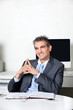 Thoughtful Happy Businessman At Desk