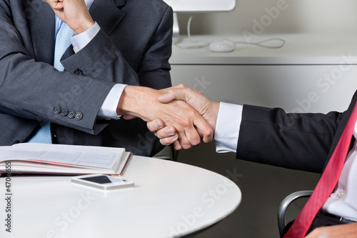 Photo: Midsection Of Businessmen Shaking Hands Midsection Of Businessmen Shaking Hands