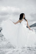 pretty young woman posing in wedding dress  on winter snow
