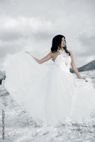 Photo: pretty young woman posing in wedding dress on winter snow pretty young woman posing in wedding dress on winter snow