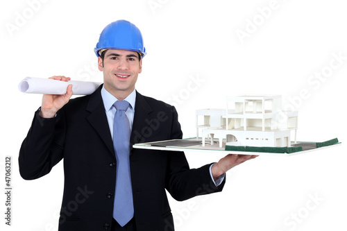 Photo: Architect with rolled-up plans and model housing Architect with rolled-up plans and model housing