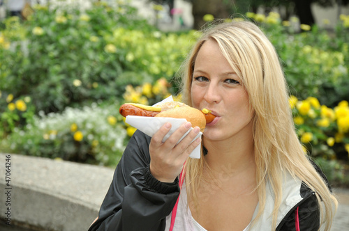 Photo: Junge Frau isst Bratwurst Junge Frau isst Bratwurst