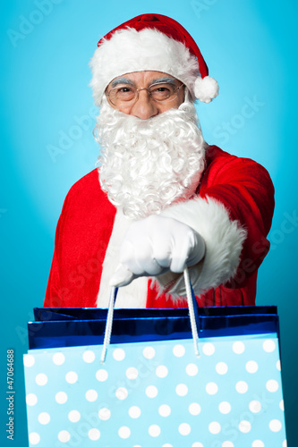 Photo: Santa holding shopping bags in his outstretched arms Santa holding shopping bags in his outstretched arms