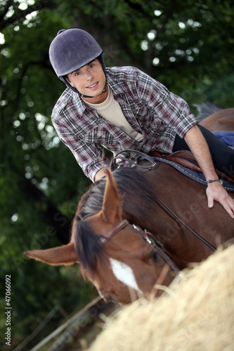 Photo: Young man riding a horse Young man riding a horse