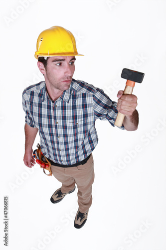 Photo: Man curiously looking at hammer Man curiously looking at hammer