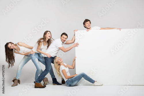 Photo: Business people pulling an empty white board Business people pulling an empty white board