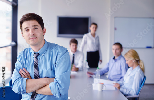 Photo: business man on a meeting in offce with colleagues in backgroun business man on a meeting in offce with colleagues in backgroun