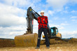 building worker in front of excavator