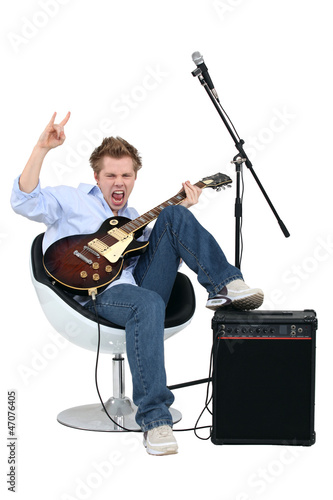 Photo: Young man with guitar playing rock music Young man with guitar playing rock music