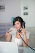 woman with a laptop computer and a phone eating a sushi