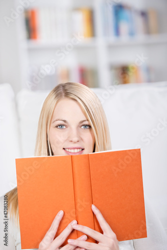 Photo: blonde frau schaut über ihr buch blonde frau schaut über ihr buch