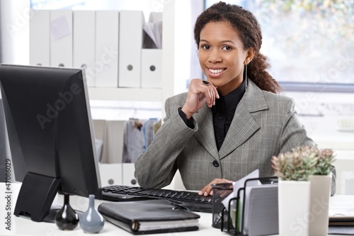 Photo: Portrait of happy businesswoman at desk Portrait of happy businesswoman at desk