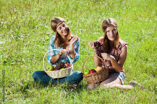 Photo: Happy young girls with a fruit basket Happy young girls with a fruit basket