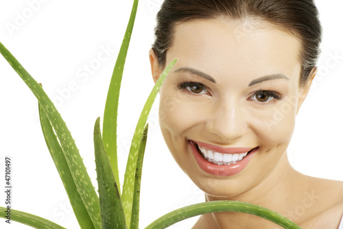Photo: Young beautiful woman's face and aloe vera. Young beautiful woman's face and aloe vera.