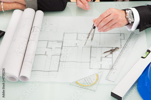 Photo: Architects discussing blueprints Architects discussing blueprints