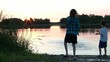 Kids Throw Rocks into Beautiful Lake with Sunset