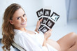 Pregnant woman holding her USG pictures