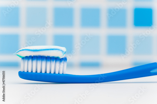 Photo: toothbrush against blue tile background toothbrush against blue tile background