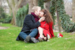 Romantic couple sitting on the grass and kissing