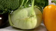 vegetables arranged on a white table, pan left