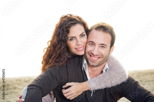 Photo: Beautiful young couple outside at the beach Beautiful young couple outside at the beach
