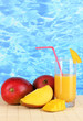 Ripe appetizing mango on woven napkin on water background
