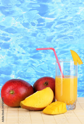 Photo: Ripe appetizing mango on woven napkin on water background Ripe appetizing mango on woven napkin on water background