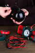 Human makes timebomb on wooden table on black background