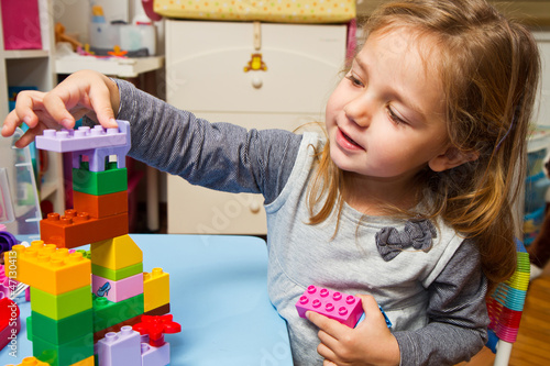 Photo: Little girl is playing with building bricks Little girl is playing with building bricks