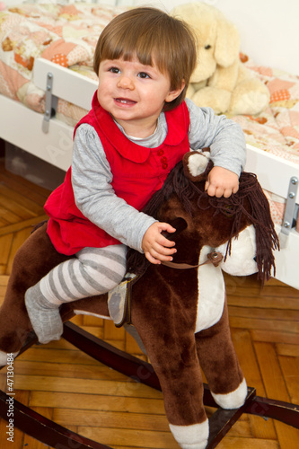 Photo: Happy little child and a rocking horse. Happy little child and a rocking horse.