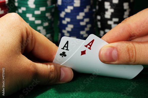 Photo: Chips and cards in hands on green table Chips and cards in hands on green table