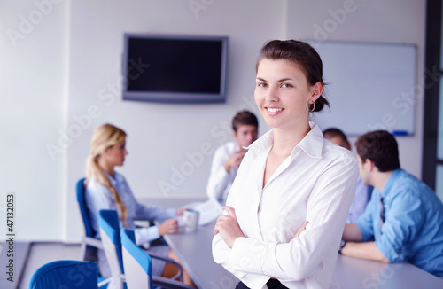 Photo: business woman with her staff in background at office business woman with her staff in background at office