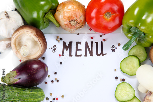 Photo: Menu surrounded by products and vegetables isolated on white Menu surrounded by products and vegetables isolated on white