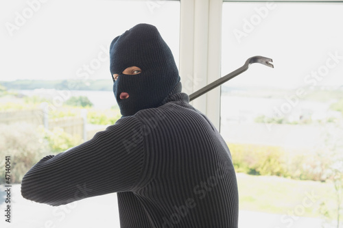 Photo: Burglar swinging crow bar Burglar swinging crow bar