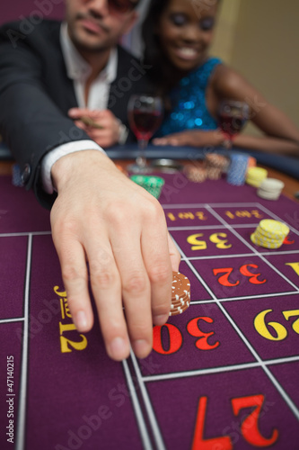 Photo: Man placing bet on roulette Man placing bet on roulette