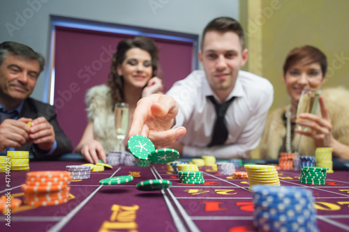 Photo: Man throwing chips down on roulette table Man throwing chips down on roulette table