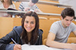 Student writing at the lecture hall