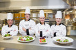 Smiling Chef's standing behind salads